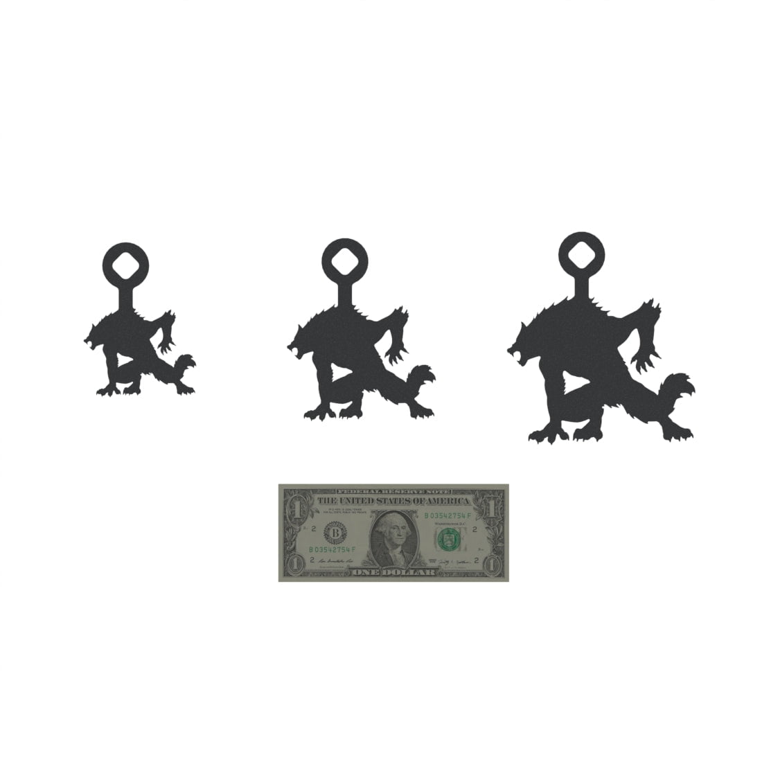 Three werewolf-shaped steel targets in varying sizes with loop hangers on top. A U.S. dollar bill is placed below for size reference.